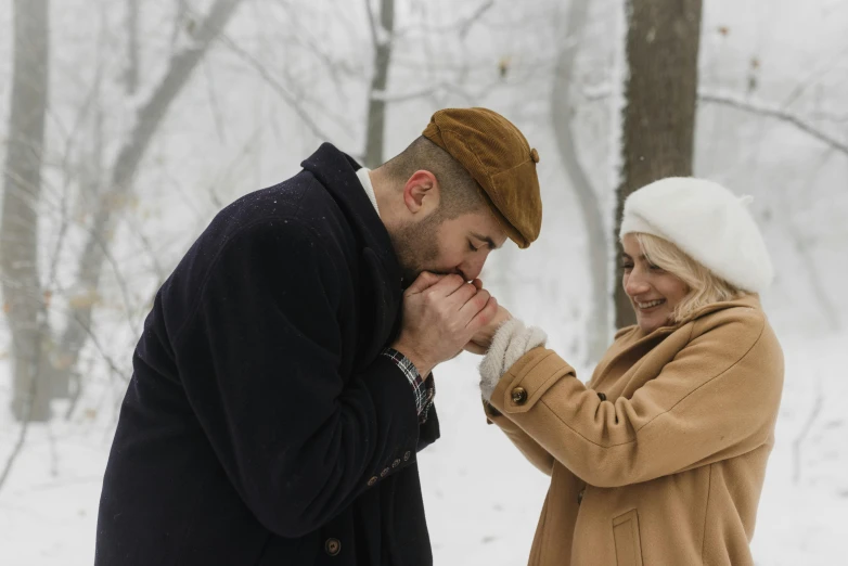 a man kissing a woman's cheek in the snow