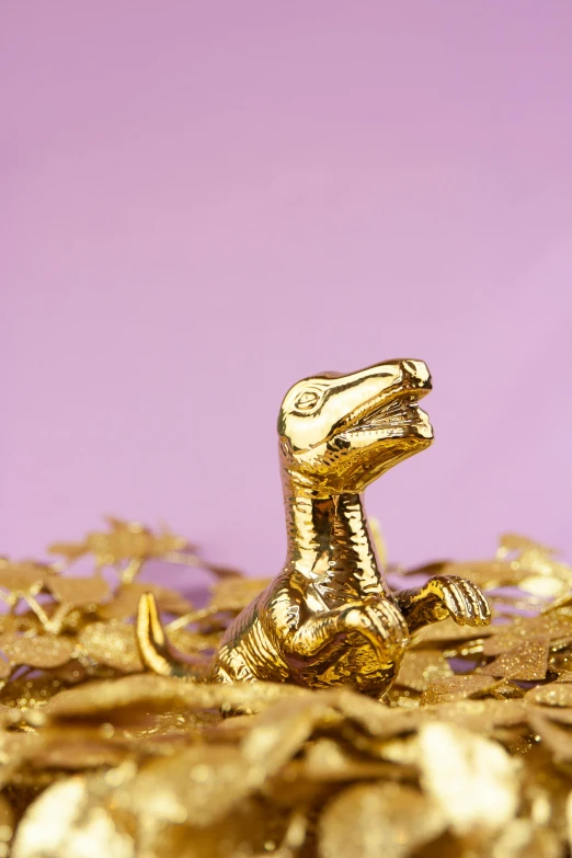 a golden toy dinosaur is in some gold foil