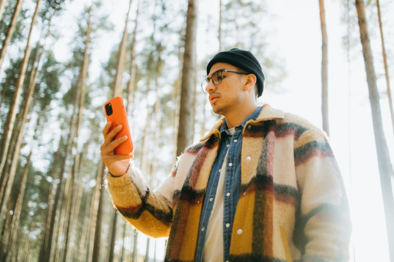 a man in a jacket is holding a cell phone