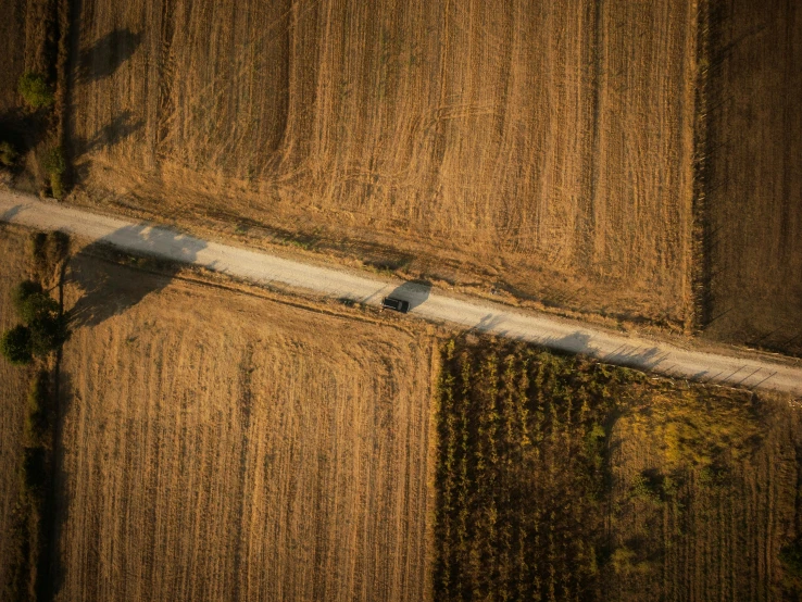 two trucks are driving on the side of a country road