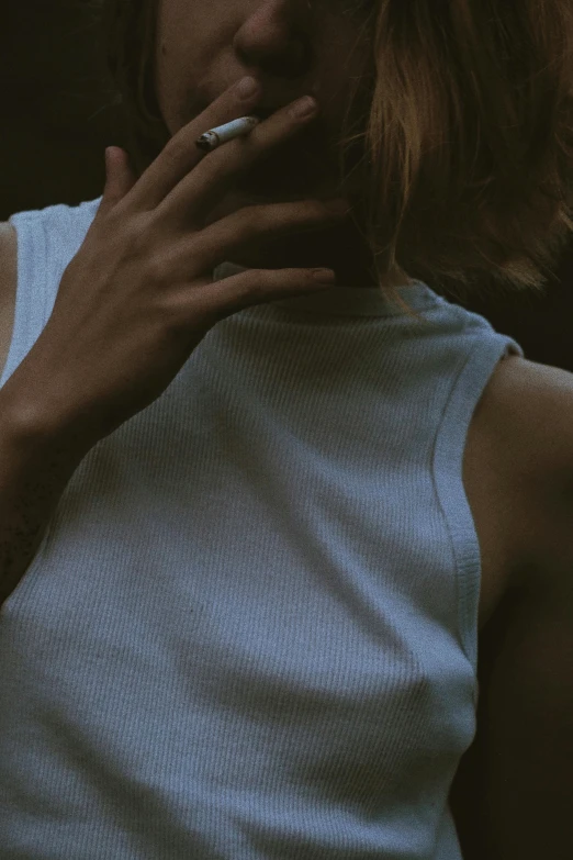 a woman with short brown hair smoking a cigarette