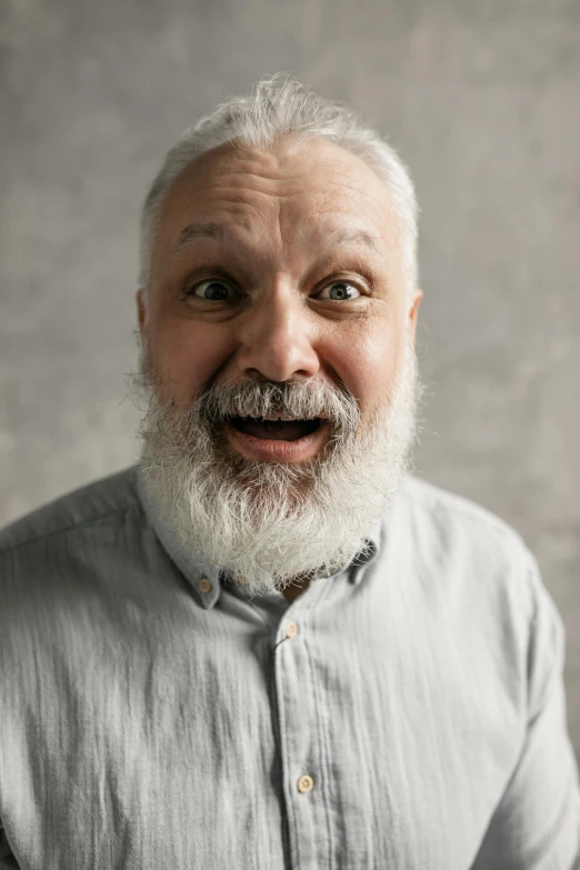 a man with white hair and beard smiles