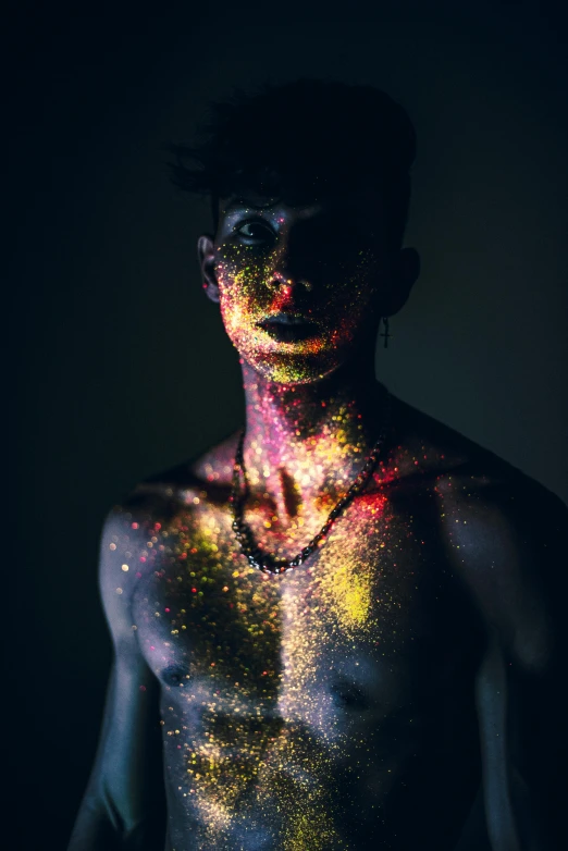 man covered in colorful powder posing for a po