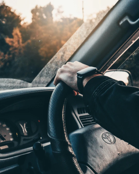 a person driving a vehicle with a steering wheel and dashboard