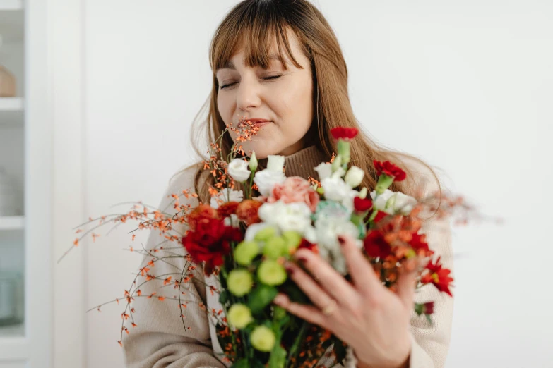 a woman holding flowers with her face in the center