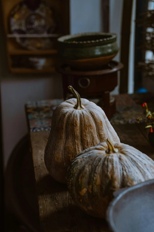 two white pumpkins sitting on top of a table