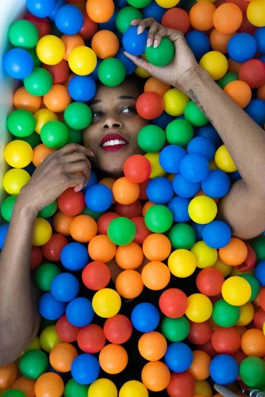 a lady is floating in a pool full of balls