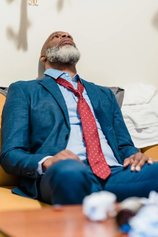 a man with his eyes closed sitting on a couch