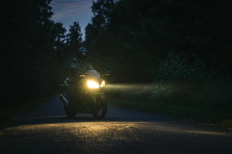 a motorcycle driver riding on the road at night