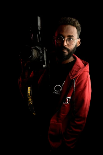 man in glasses with camera with dark background