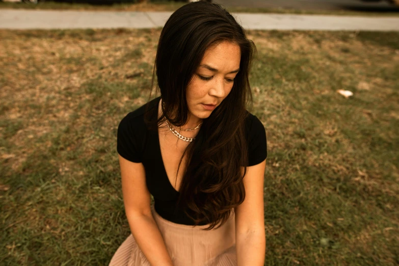 a young woman sitting on the ground playing with a frisbee