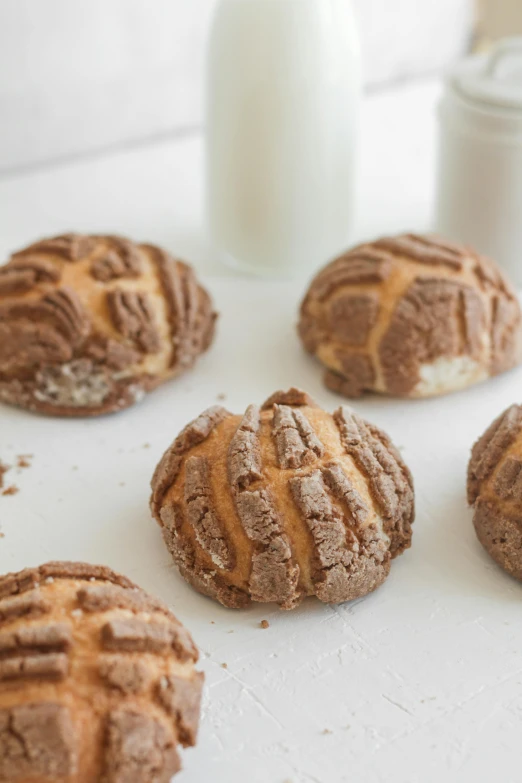 a white plate topped with brown cookies next to a glass of milk