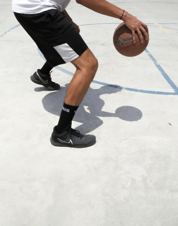 a man holding a basketball standing on top of a basketball court