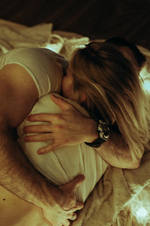 a woman laying in bed with a white dog