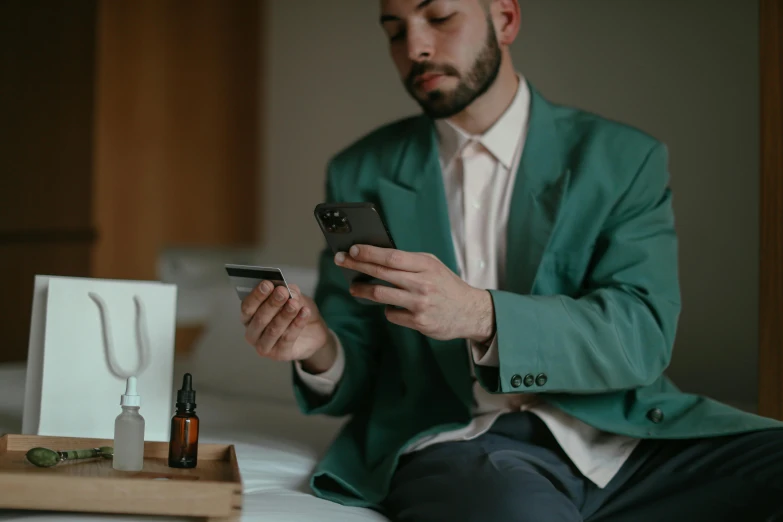 a man holding a smart phone and some bottles