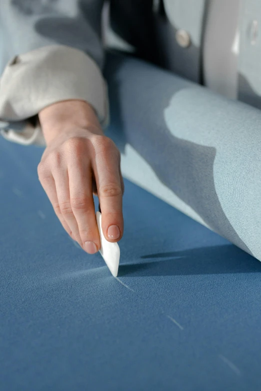 a persons hand holds out a paper blade