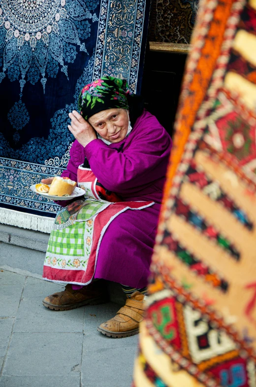 a lady with a basket that is sitting next to a rug