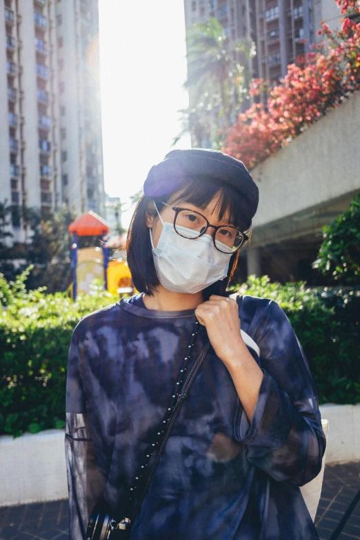 woman with a mask on and jacket jacket wearing glasses