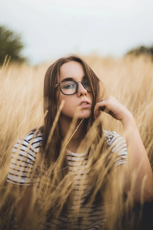 a beautiful young woman posing in a field of wheat