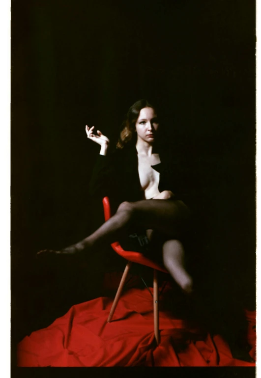 woman in black outfit sitting on red chair