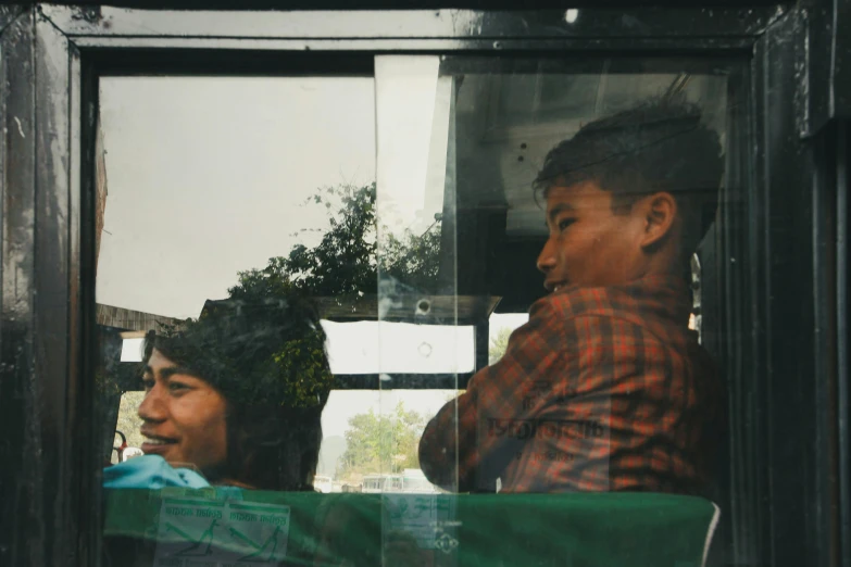 two people with hats, one in a seat and the other out