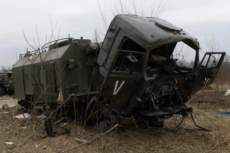 two army vehicles parked next to each other in the dirt