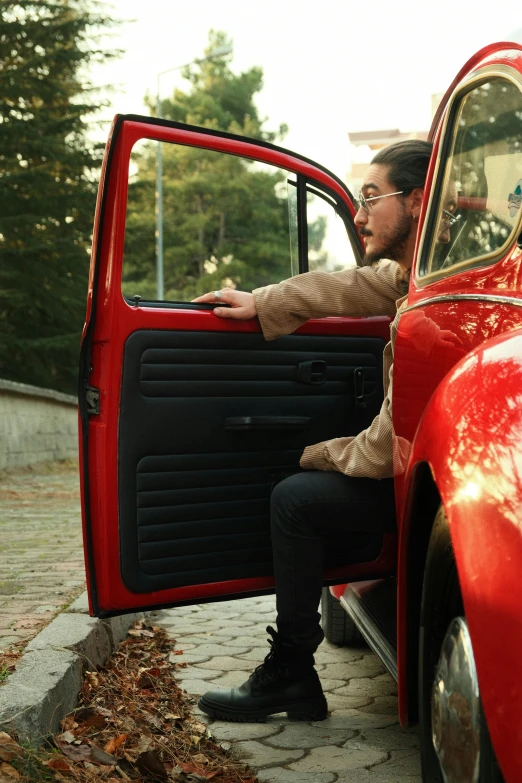 a man in glasses riding a red pickup truck