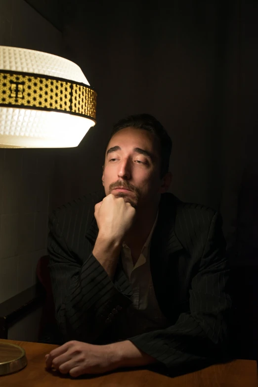 a man that is sitting under a lamp
