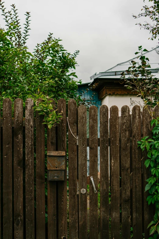 a tall wooden fence next to a house