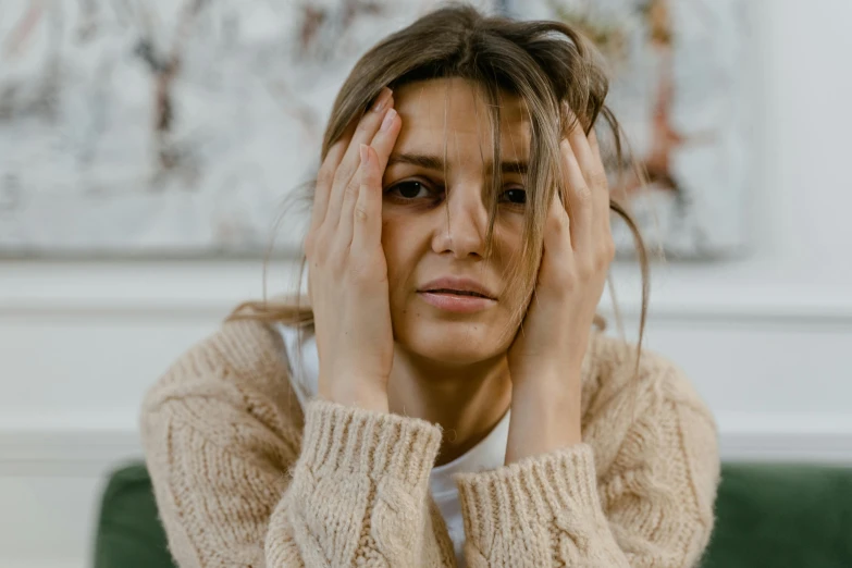 a woman sitting with her hands to her head