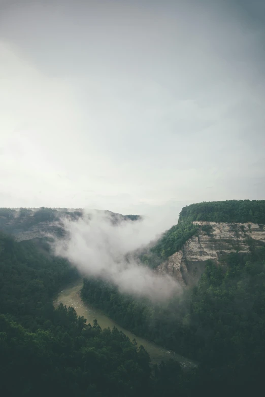 a landscape s of a mountain with low clouds in the sky