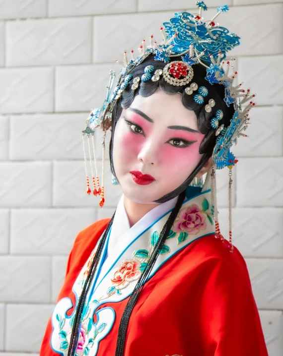 a woman wearing oriental makeup and headdress with jewelry