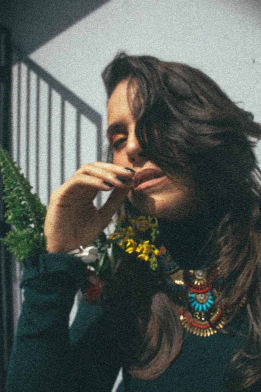 a woman covering her mouth with flowers in the foreground