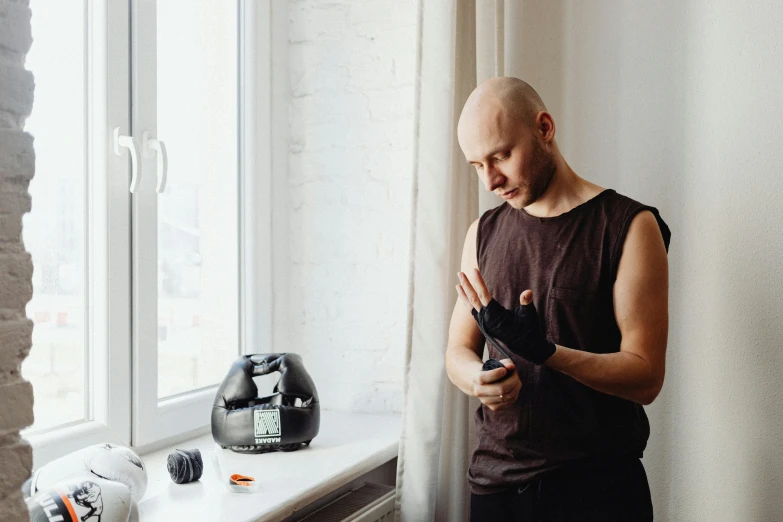 a bald man standing by a window next to a microwave and coffee maker