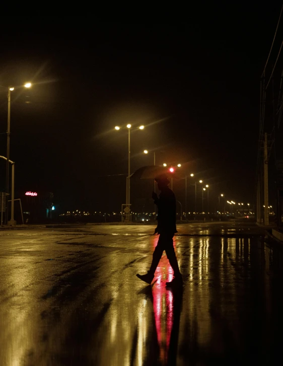 a dark street with some lights in it and a person standing in the dark