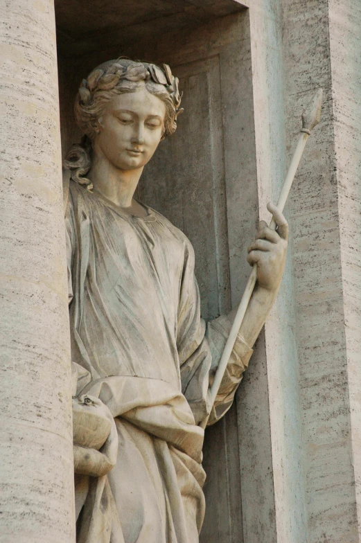 a statue holding a stick with both hands