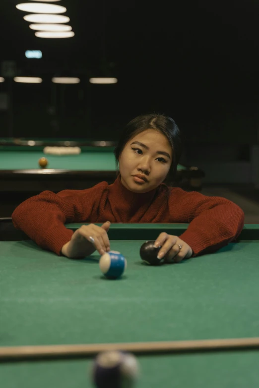 a woman playing pool is leaning on the wall