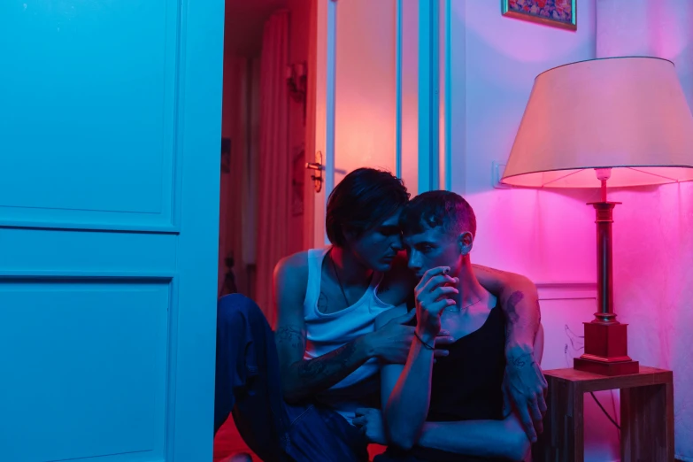 two people sitting in a room with blue and red lighting