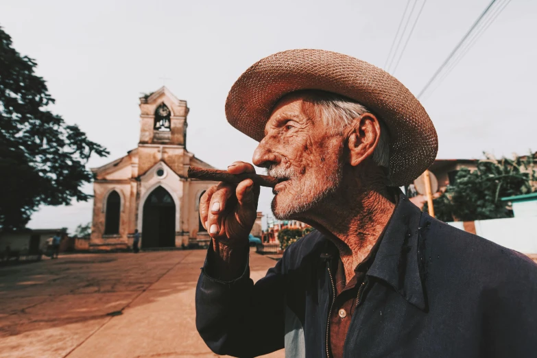 the old man is smoking a cigarette near the church