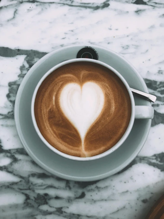 a cup of coffee with a heart shape on it