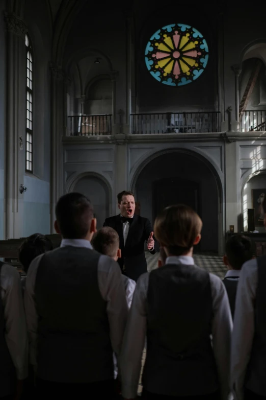 a choir sings while a man stands behind them