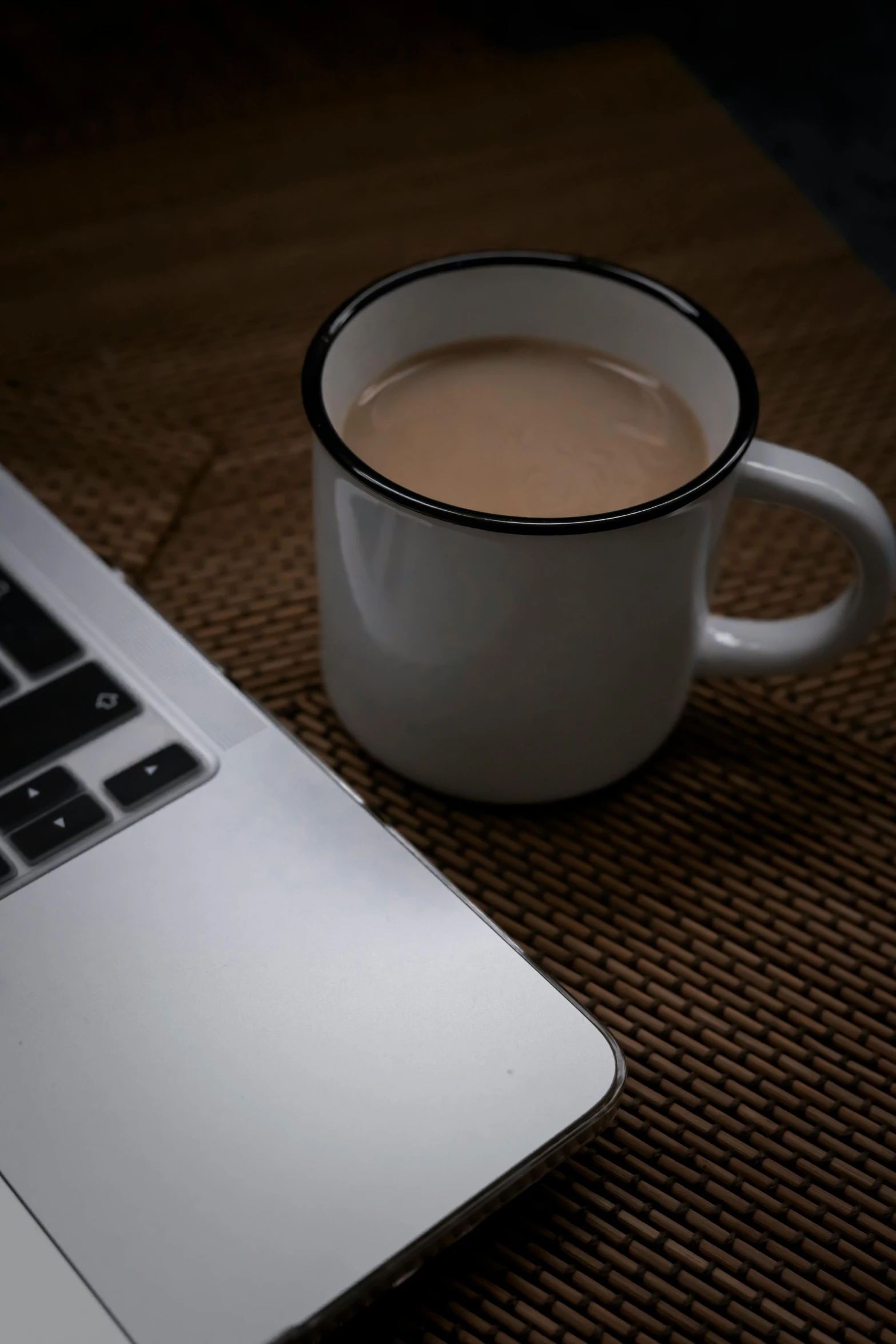 a cup of coffee next to an open laptop