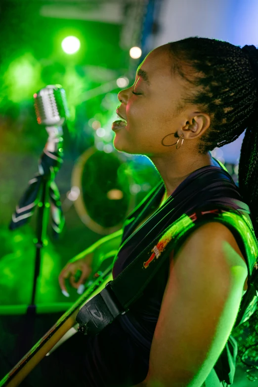 an african woman singing into a microphone and another person standing behind her
