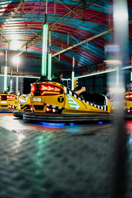 several bumper cars in a parking lot at night