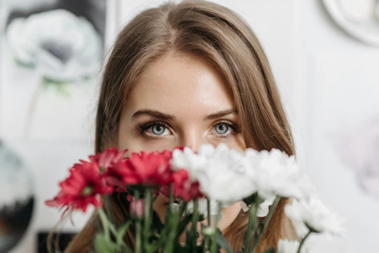 a woman standing next to flowers looking off into the distance