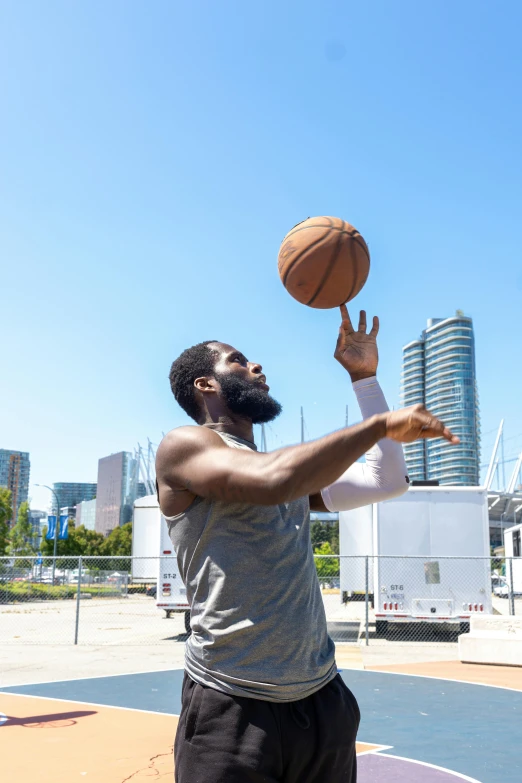 a man in grey shirt throwing a basketball