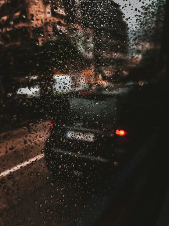 a car parked on the side of the road in a rain soaked window