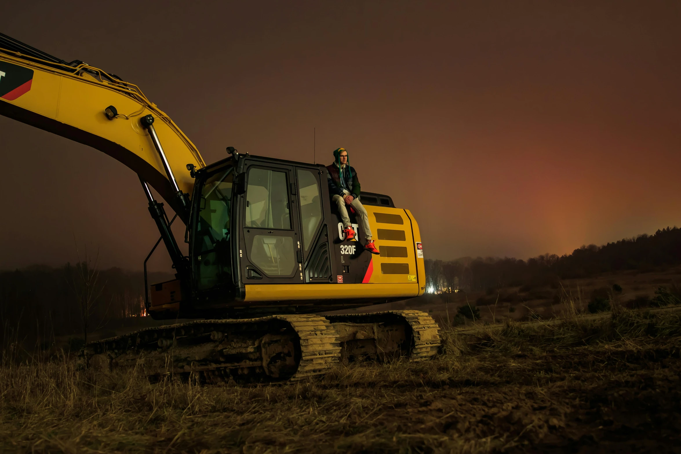 a large backhoe on a hillside with a man standing in it