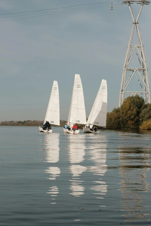 some very pretty white sailboats by some big water