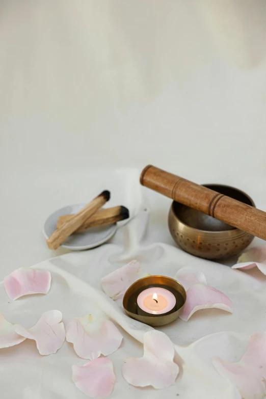 a small candle is next to a dish and two spoons